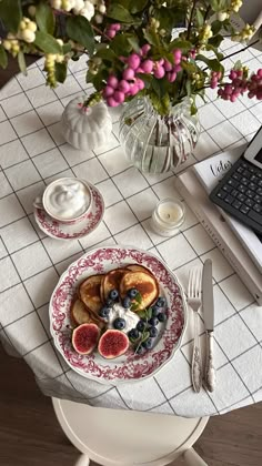 a plate with fruit on it next to a laptop