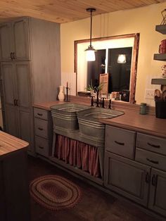 a kitchen with wooden floors and gray cabinets