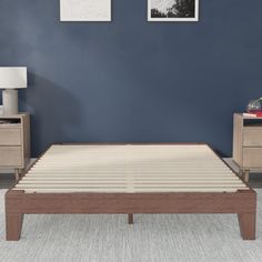 a bed with two nightstands next to it in a blue walled room, and a white rug on the floor