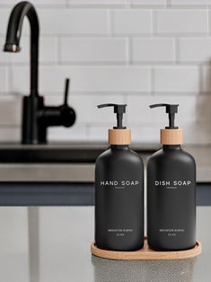 two black soap dispensers sitting on top of a counter