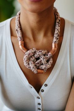 a woman wearing a necklace made out of rope