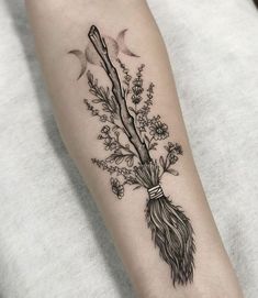 a woman's arm with flowers and branches on it