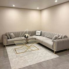 a living room with a couch, coffee table and rug on the floor in front of it