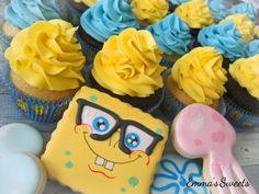 some cupcakes with yellow frosting and blue icing are on a table