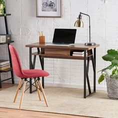 a desk with a laptop on it in front of a white brick wall and potted plants