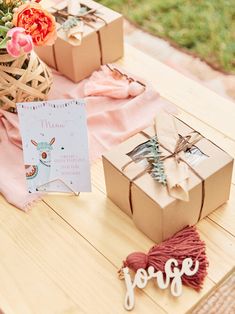 two boxes are sitting on a table with some flowers and other items next to it