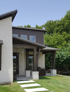 a modern house with stone steps leading to the front door