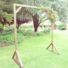 two wooden swings in the grass near trees