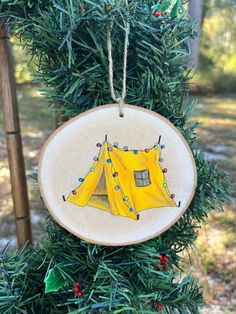 a yellow tent ornament hanging from a christmas tree