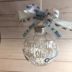 a glass ornament hanging from the ceiling with baby's footprints on it