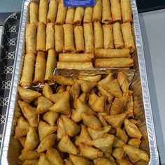 several trays filled with food sitting on top of a metal table next to each other