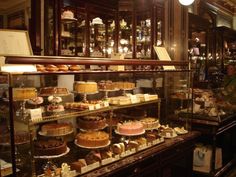 a display case filled with lots of different types of cakes and pastries in a bakery