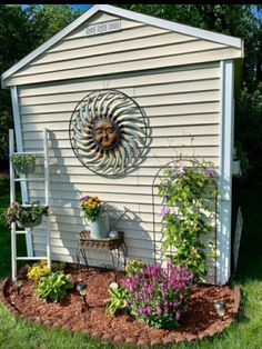 a garden shed with flowers and plants growing in it's flowerbeds on the side