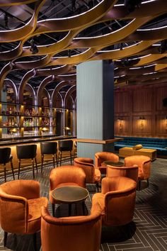 an elegant bar with orange chairs and stools