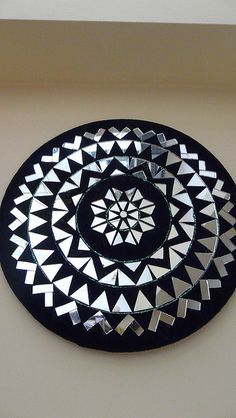 a black and white circular mirror hanging on the wall