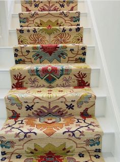 the carpeted stairs are decorated with colorful rugs