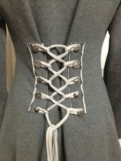 the back of a woman's gray coat with white laces