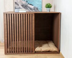 a wooden cabinet with a dog bed in the bottom and a painting on the wall behind it