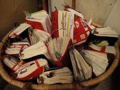 a basket filled with lots of books sitting on top of a floor next to a wall