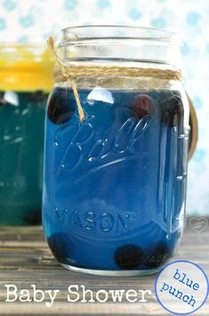 two mason jars with blueberries and lemons in them are sitting on a table