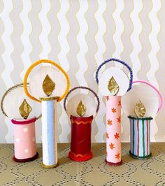 four different colored vases sitting next to each other on top of a table in front of a wall