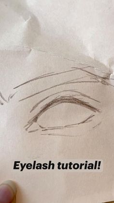 someone is holding up a piece of paper with an eye drawn on it