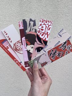 a person holding up several different types of stickers