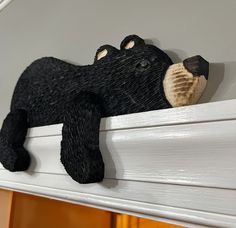 a black bear figurine sitting on top of a window sill next to a door