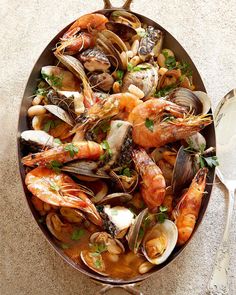 a pan filled with seafood and clams on top of a table