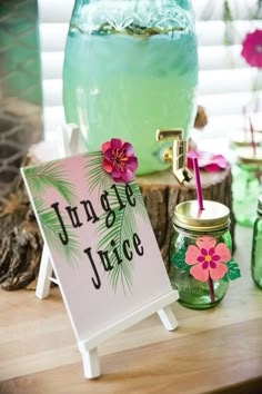 there is a sign that says jungle juice next to some jars with flowers on them