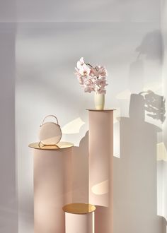 three pink vases with flowers in them sitting next to each other