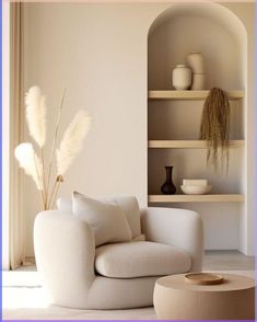 a white chair sitting in front of a shelf filled with vases