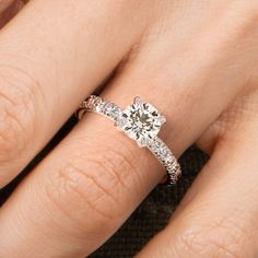 a woman's hand with a diamond ring on top of her finger and an engagement band