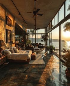 a bedroom with large windows overlooking the water and palm trees in front of an ocean view