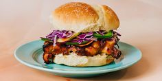 a chicken sandwich with coleslaw and slaw on a blue plate against a beige background