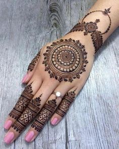 a woman's hand with henna tattoos on it