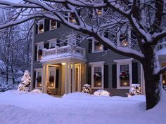 a house is covered in snow with christmas lights