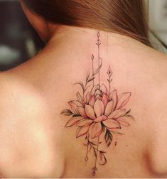 a woman's back with a flower tattoo on it