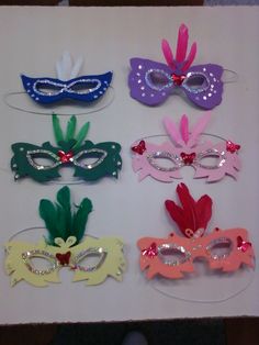 six masquerade masks are lined up on a table