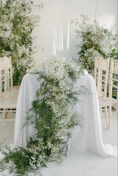 the table is set with white flowers and candles