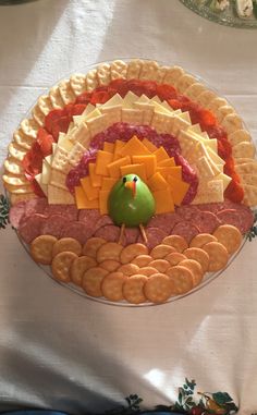 a turkey shaped platter with crackers and fruit on it, sitting on a table