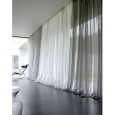 a black and white photo of a room with sheer curtains