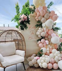 balloons and greenery decorate the backdrop for a baby shower