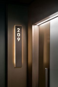 an illuminated sign on the side of a door that reads 2099 in white letters