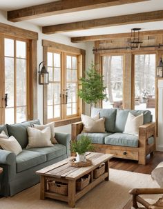 a living room filled with lots of furniture next to large windows and wooden beams on the ceiling