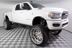 a white truck is parked in a room with black and white checkered flooring