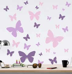 the wall is decorated with purple butterflies and shades of light pink, which are scattered across the room