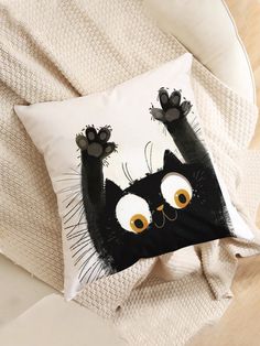 a black cat pillow sitting on top of a bed