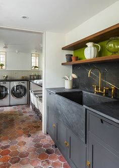 a washer and dryer in a room with tile flooring on the walls