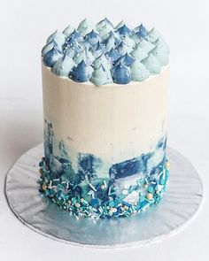 a blue and white cake with frosting on top